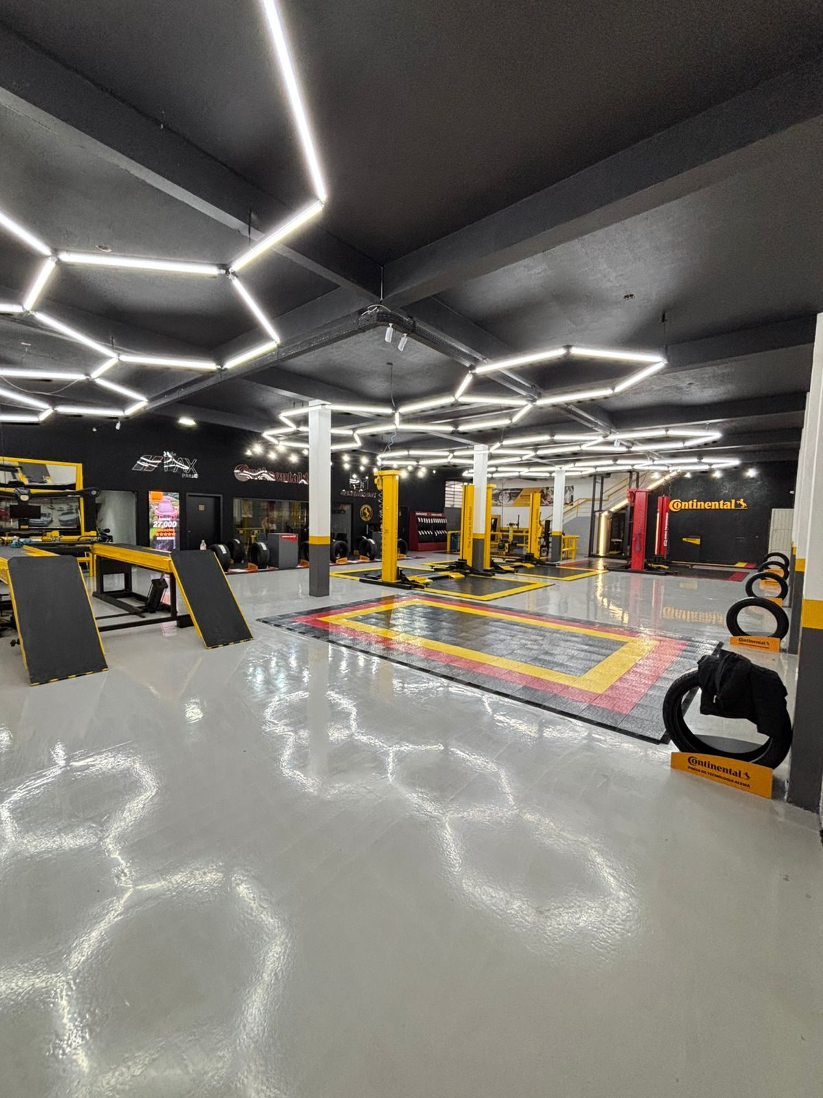 Oficina de autocenter com piso claro e iluminação hexagonal